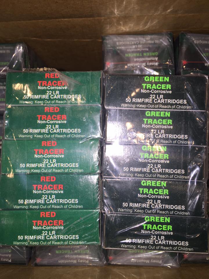 Stacks of green boxes of red and green tracer .22 LR rimfire cartridges wrapped in plastic