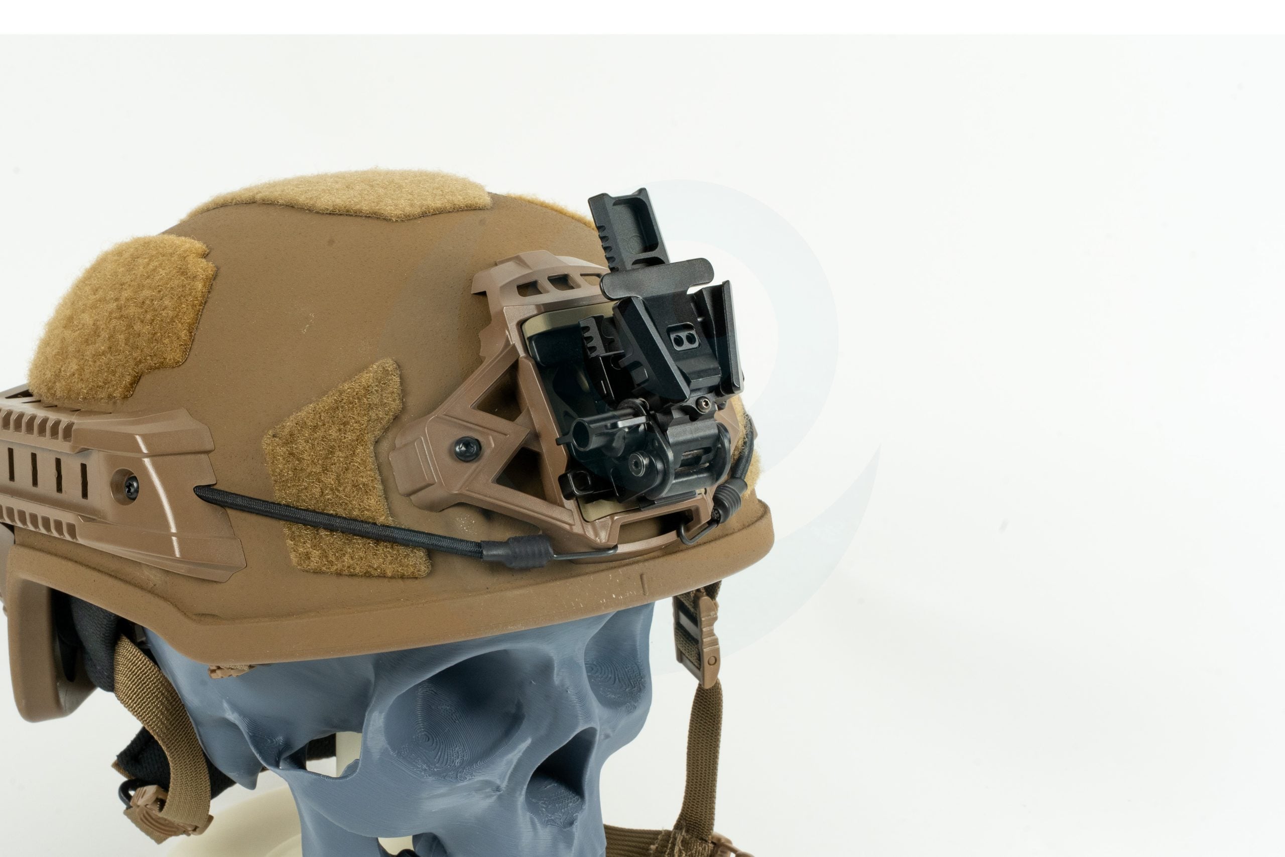 Tactical helmet with night vision mount displayed on a skull model against a white background.